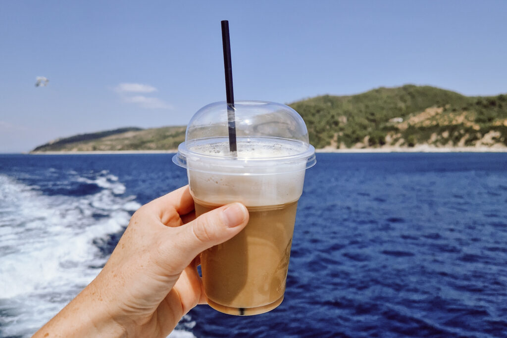 kawa w dłoni, na tle morza