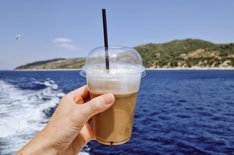 kawa w dłoni, na tle morza